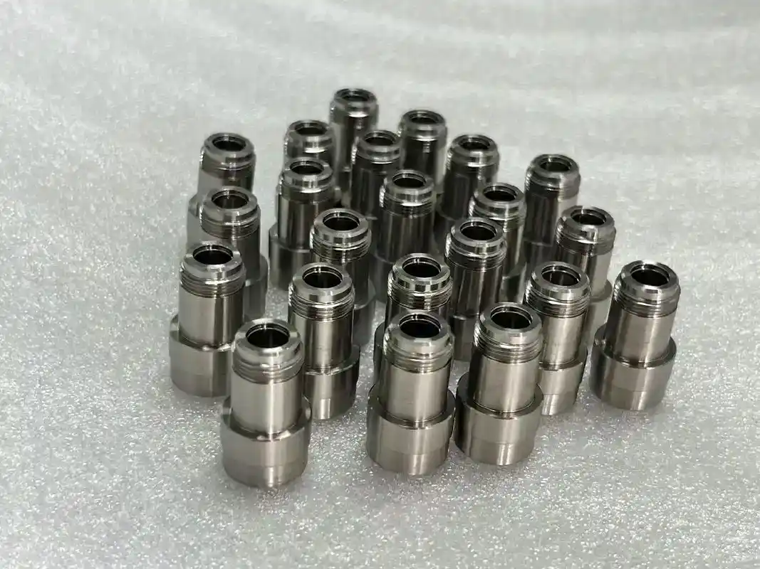 Precision-machined metal CNC parts arranged on a textured surface for manufacturing.