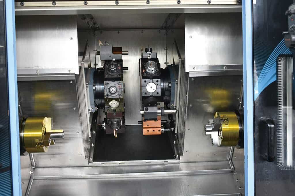 Multi-axis mill-turn center with dual spindles and a B-axis powered turret