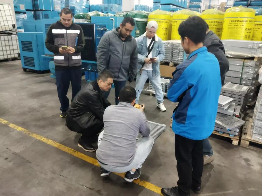 Besucher und das 6CNC-Team prüfen ein gefertigtes Bauteil in der Werkstatt.